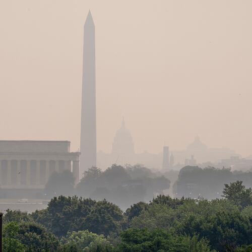The Lincoln Memorial, the Washington Monument, and the U.S. Capitol, are barely visible from an overlook in Arlington, Va., as heavy smoke from wildfires shrouds the landscape in Washington, Friday, July 17, 2026. (AP Photo/J. Scott Applewhite)