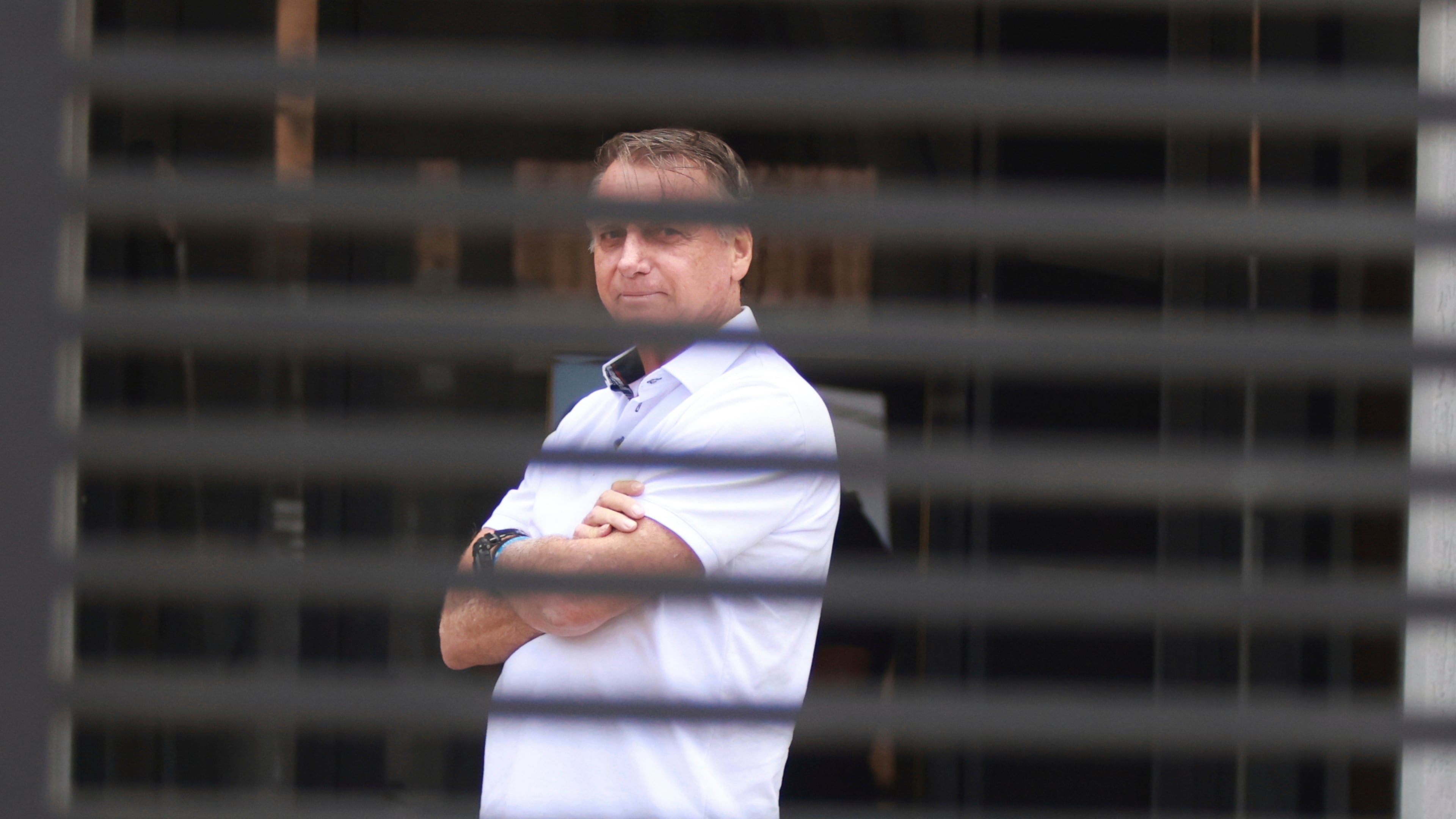 Brazil's former President Jair Bolsonaro stands at the entrance of his home where he is under house arrest in Brasilia, Brazil, Tuesday, Sept. 2, 2025. (AP Photo/Luis Nova)