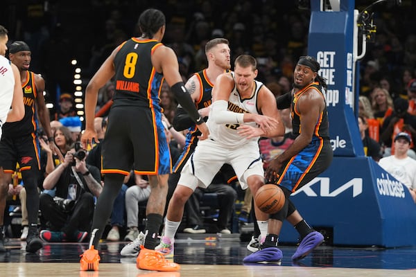 Denver Nuggets center Nikola Jokic, center, loses control of the ball as Oklahoma City Thunder's Jalen Williams (8), Isaiah Hartenstein, center rear, and Luguentz Dort, right, defend in the second half of Game 2 in the conference semifinals of the NBA basketball playoffs, Wednesday, May 7, 2025, in Oklahoma City. (AP Photo/Kyle Phillips)
