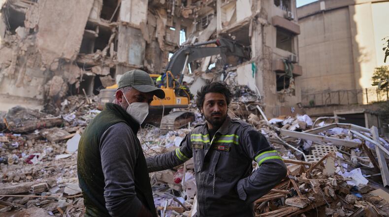 A Lebanese civil defense worker, right, stands with a resident at the site of a building destroyed in an Israeli airstrike a day earlier in central Beirut, Lebanon, Thursday, April 9, 2026. (AP Photo/Hassan Ammar)