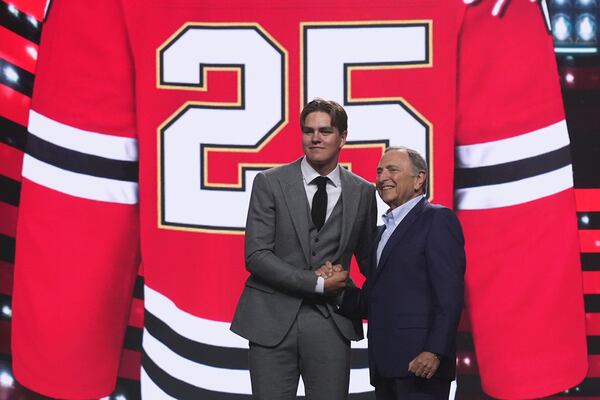 Anton Frondell, left, is congratulated by NHL commissioner Gary Bettman after being drafted by the Chicago Blackhawks during the NHL hockey draft Friday, June 27, 2025, in Los Angeles. (AP Photo/Damian Dovarganes)