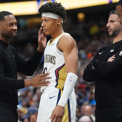 New Orleans Pelicans head coach Willie Green, left, confers with guard Jeremiah Fears, center, as assistant coach James Borrego looks on in the first half of an NBA basketball game against the Denver Nuggets Wednesday, Oct. 29, 2025, in Denver. (AP Photo/David Zalubowski)