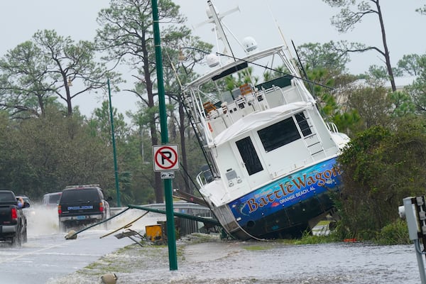 FILE - A boat is washed up near a road after Hurricane Sally moved through the area, Wednesday, Sept. 16, 2020, in Orange Beach, Ala. (AP Photo/Gerald Herbert, file)