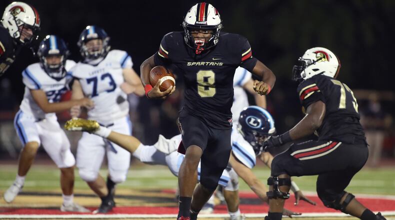 GAC quarterback Deymon Fleming (8) runs for yardage in the first half of a recent game against Lovett in Norcross. (Jason Getz/Special to the AJC)