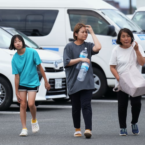 People arrive at the Hikawa Town Hall to receive food and water supplies in Hikawa, southern Japan, Thursday, July 30, 2026, two days after an earthquake hit the area. (AP Photo/Hiro Komae)