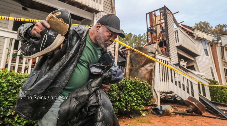 Stanley Anderson carries what few belongings he could salvage from his water-logged apartment Monday morning after fire ripped through one building in the Polo Club complex Sunday night.