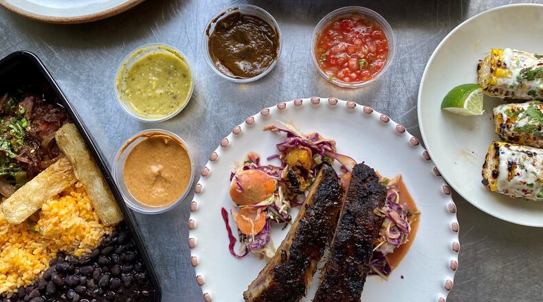 Takeout from Bar Mercado includes (clockwise from upper left):  grilled shrimp, with crispy okra; grilled Peruvian-spiced chicken, with black beans, rice and Salvadoran slaw; Mexican street corn; glazed ribs, with pineapple slaw; short-rib ropa vieja, with beans, rice and yuca fries. Wendell Brock for The Atlanta Journal-Constitution