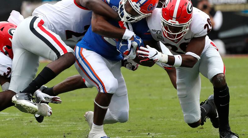 A pack of Bulldogs combine to stop Florida running back Lamical Perine Saturday in Jacksonville. (BOB ANDRES / ROBERT.ANDRES@AJC.COM)