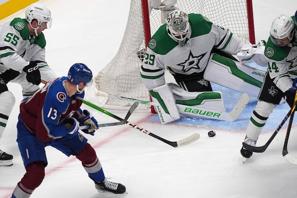 Colorado Avalanche right wing Valeri Nichushkin (13) shoots the puck past Dallas Stars defenseman Thomas Harley (55) as Stars goaltender Jake Oettinger (29) covers the net in the first period of Game 6 of an NHL hockey first-round playoff series Thursday, May 1, 2025, in Denver. (AP Photo/David Zalubowski)