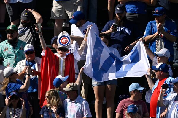 A Chicago Cubs fan dressed as a pope holds a "W" flag after the Cubs defeated the Chicago White Sox in a baseball game Friday, May 16, 2025, in Chicago. (AP Photo/Paul Beaty)