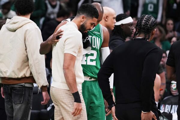 Boston Celtics forward Jayson Tatum, who is sidelined with an injury, gets a pat on the back from center Al Horford during the first half in game 2 of a first-round NBA playoff basketball series, Wednesday, April 23, 2025, in Boston. (AP Photo/Charles Krupa)