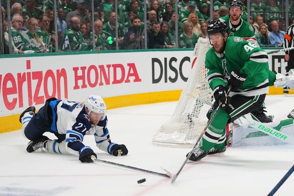 Winnipeg Jets' Nikolaj Ehlers (27) and Dallas Stars' Ilya Lyubushkin (46) work to control the puck in the second period of Game 3 of a second-round NHL hockey playoff series in Dallas, Sunday, May 11, 2025. (AP Photo/Julio Cortez)