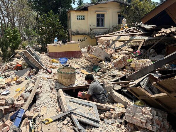 A person goes through rubble at a Buddhist monastery building that has collapsed following an earthquake in Naypyitaw, Myanmar Sunday, March 30, 2025. (AP Photo/Aung Shine Oo)