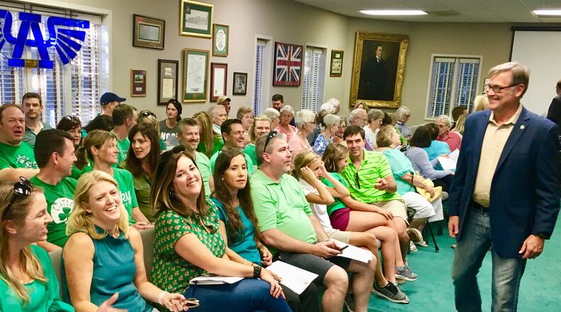 Avondale Estates Mayor Jonathan Elmore greets supporters before Thursday’s commission meeting. The green shirts, far from matching the carpet, signify support (or “go”) for the the 270-apartment project which commissioners later approved. The portrait of city founder George Willis looms in the background. Bill Banks for the AJC
