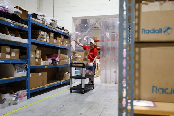 World Micro clerk Tim Prevatt works in the warehouse in Roswell. World Micro is trying to figure out how to get a refund on tariffs it paid. (Jason Getz/AJC 2025)