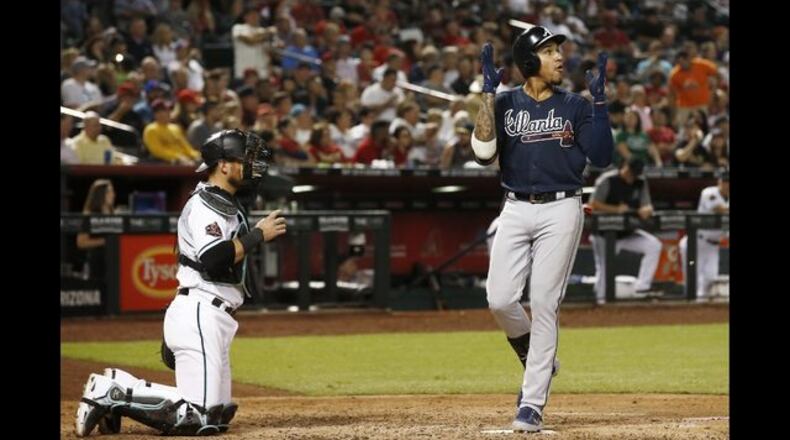 Atlanta Braves' Johan Camargo, right, claps as he arrives at home plate after hitting a home run Thursday. (AP Photo/Ross D. Franklin)