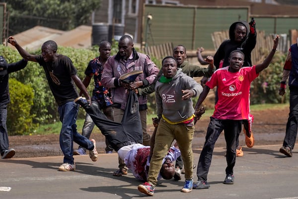 Protester carry a man who the crowd claimed had been shot by police, during the historic 1990 Saba Saba, a Swahili word that means seven seven, protests for democratic reforms in the Kangemi slum of Nairobi, Kenya Monday, July 7, 2025. (AP Photo/Brian Inganga)