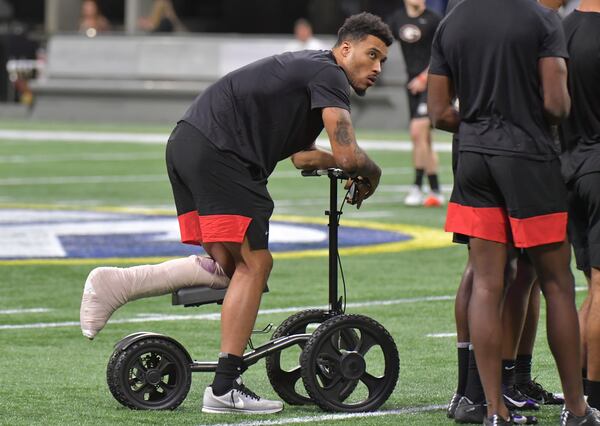 Injured Georgia wide receiver Lawrence Cager is with teammates on the football field at Mercedes-Benz Stadium on Friday, December 6, 2019. (Hyosub Shin / Hyosub.Shin@ajc.com)