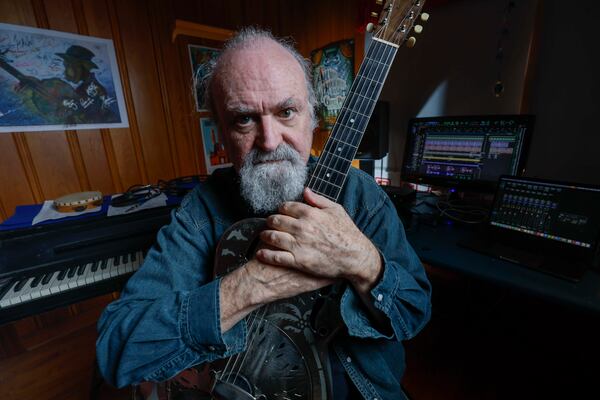 “The older I get, the more I realize that everything boils down to how people treat each other," says Ellis, embracing his 1937 guitar at his studio in Atlanta. (Miguel Martinez/AJC)