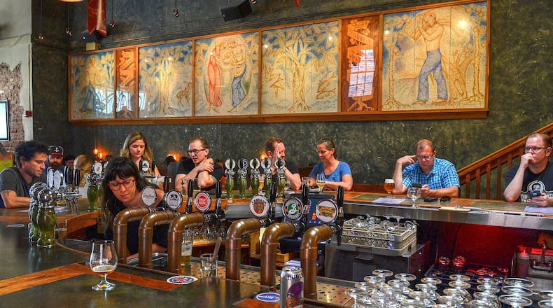 Meagan Horan works behind the horseshoe-shaped bar that anchors the original downstairs section of the Brick Store Pub in Decatur. CHRIS HUNT/SPECIAL