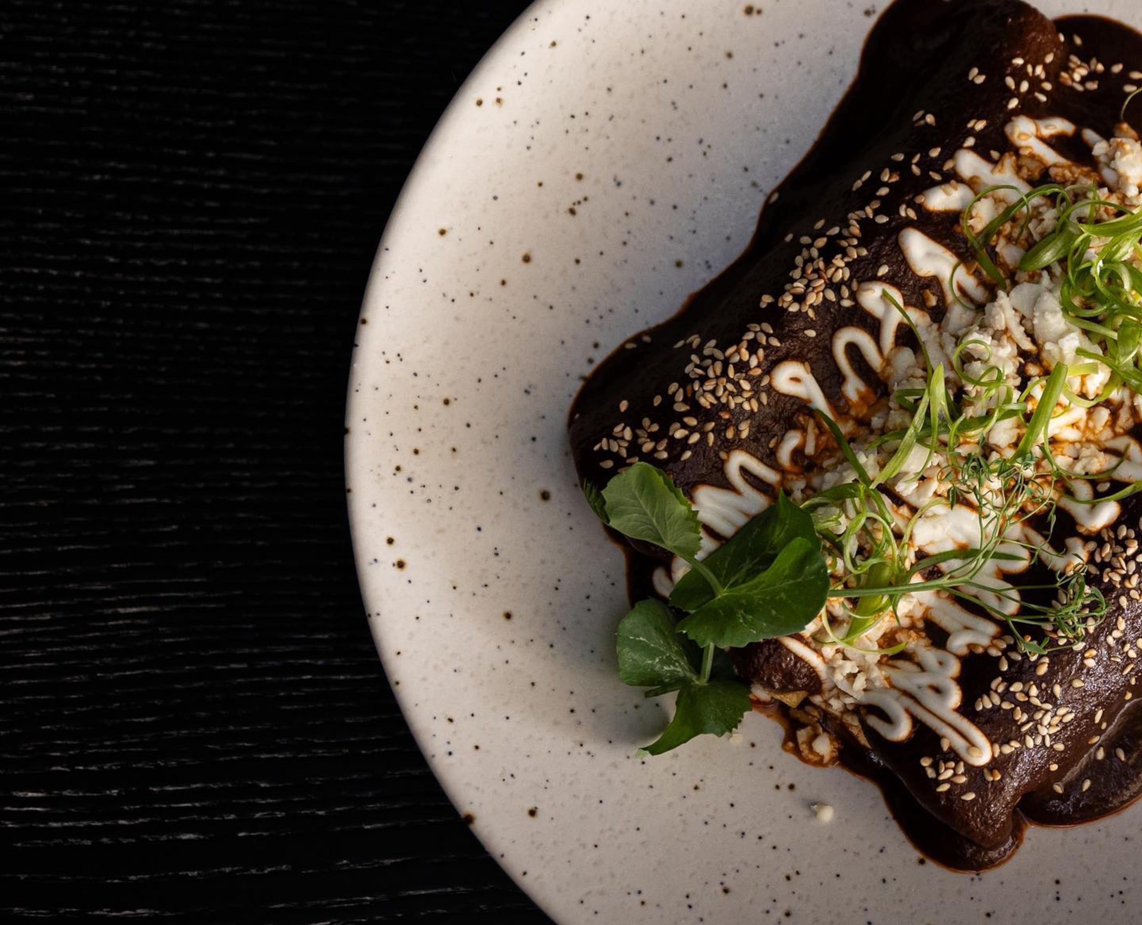 Enmoladas at Pata Negra are simple enchiladas enveloped in the anything-but-simple mole negro sauce. (Courtesy of Pata Negra)