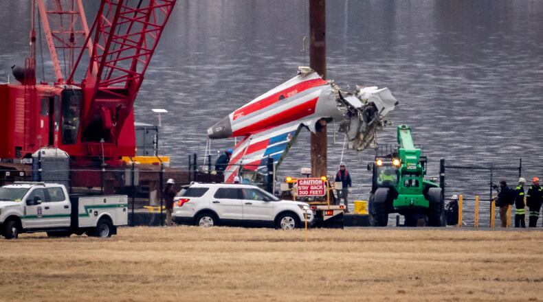 FILE - A crane offloads a piece of wreckage from a salvage vessel onto a flatbed truck, near the wreckage site in the Potomac River of a mid-air collision between an American Airlines jet and a Black Hawk helicopter, at Ronald Reagan Washington National Airport, Feb. 5, 2025, in Arlington, Va. (AP Photo/Ben Curtis, File)