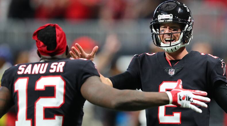 Falcons quarterback Matt Ryan gives wide receiver Mohamed Sanu five after he played quarterback for one play and threw a touchdown pass to Julio Jones during the first half against the Buccaneers Sunday, Nov. 26, 2017, in Atlanta.