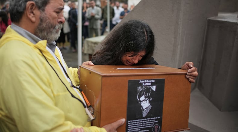 Ana Ramos cries as she holds the remains of her brother Jose Eduardo Ramos, who along with his wife Alicia Dora Cerrota was kidnapped and disappeared by the Argentine dictatorship in 1976, at the cemetery for burial in Tafi Viejo, Thursday, March 5, 2026.(AP Photo/Victor R. Caivano)