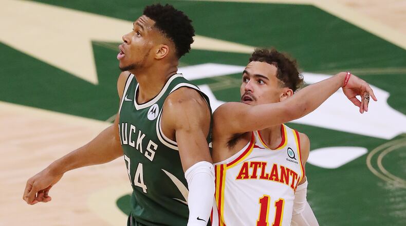 Hawks guard Trae Young watches his shot drop against Milwaukee Bucks defender Giannis Antetokounmpo during the fourth quarter of Game 1 of the Eastern Conference finals Wednesday, June 23, 2021, in Milwaukee. (Curtis Compton / Curtis.Compton@ajc.com)