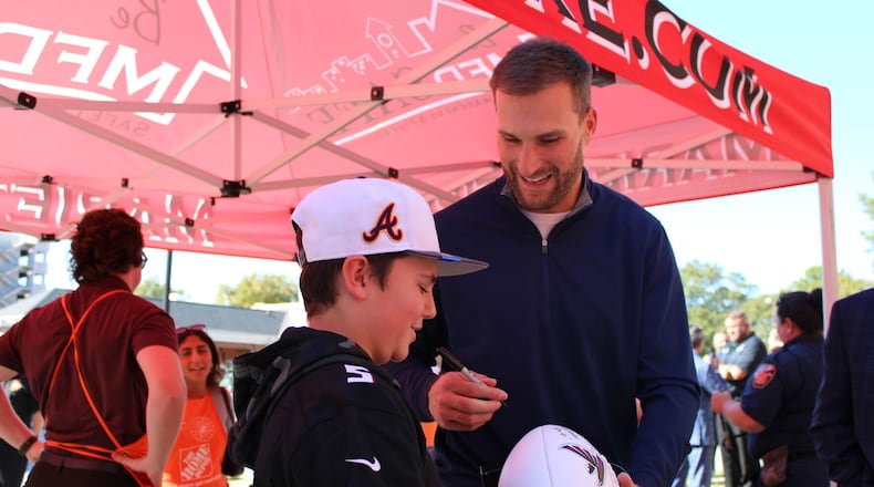 Quarterback Kirk Cousins signs a football for Easton Pavon, 12, during Kidde’s Cause For Alarm donation event at the Marietta Fire Museum Monday. (Photo Courtesy of Isabelle Manders)