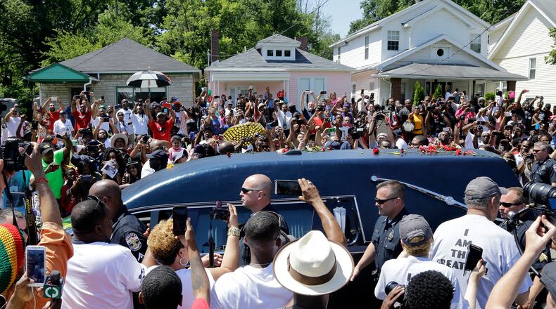 The hearse carrying the body of Muhammad Ali passes in front of his boyhood home, top center, during his funeral procession Friday, June 10, 2016, in Louisville, Ky. (AP Photo/Mark Humphrey)