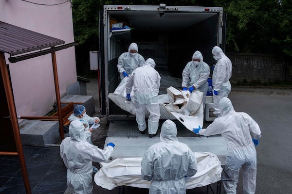 Ukrainian servicemen carry a body repatriated from Russia, at the morgue in Kyiv, Ukraine, on Thursday, June 26, 2025. (AP Photo/Evgeniy Maloletka)