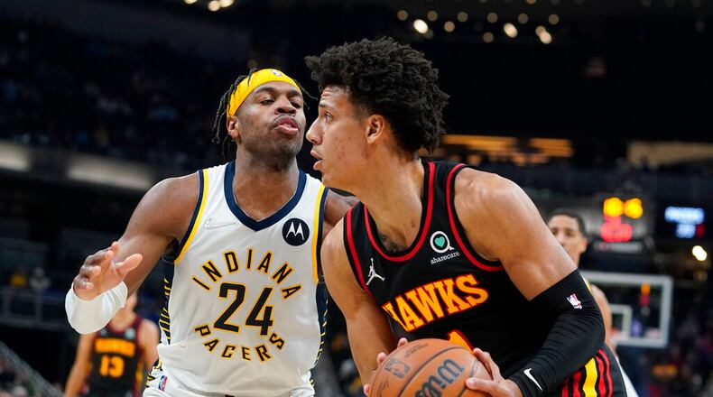 Jalen Johnson, right, looks to shoot against Indiana Pacers' Buddy Hield (24) during the first half of an NBA basketball game, Monday, March 28, 2022, in Indianapolis. (AP Photo/Darron Cummings)