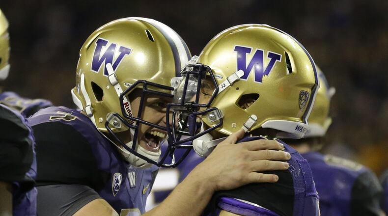 Washington quarterback Jake Browning (left) celebrates with wide receiver Aaron Fuller after Fuller caught a touchdown pass from Browning earlier this season. (AP Photo/Ted S. Warren, File)