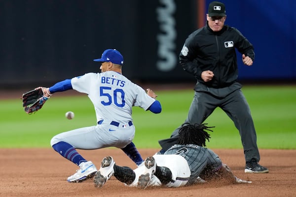 New York Mets' Luisangel Acuña, bottom right, steals second base while Los Angeles Dodgers shortstop Mookie Betts, left, cannot make a catch during the eighth inning of a baseball game, Sunday, May 25, 2025, in New York. (AP Photo/Seth Wenig)