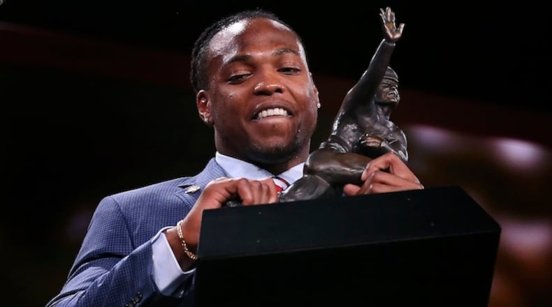 Alabama's Derrick Henry lifts up the Heisman Trophy after being announced as the winner, Saturday, Dec. 12, 2015, in New York. (AP Photo/Kelly Kline, Pool)