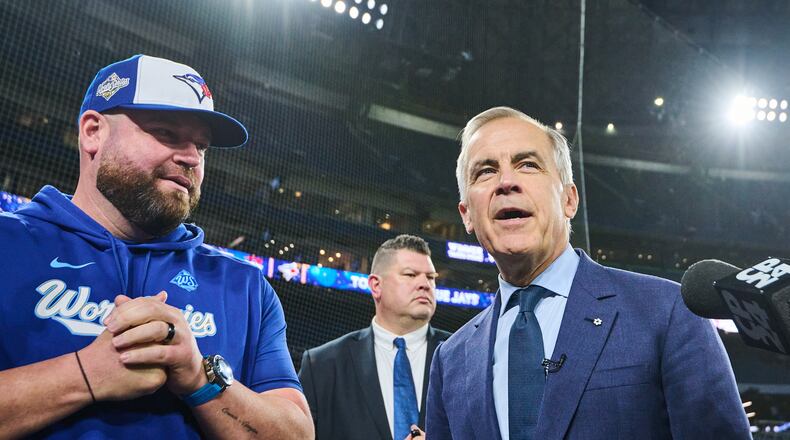 Canada's Prime Minister Mark Carney speaks to Toronto Blue Jays manager John Schneider as he visits the Blue Jays during baseball's World Series media day, Thursday, Oct. 23, 2025, in Toronto,. (Sammy Kogan/The Canadian Press via AP)