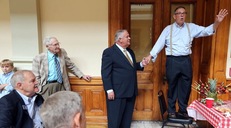 July 24, 2013 Atlanta: Robby Rivers, right, clerk of the Georgia House of Representatives since 1991, holds court while holding House Speaker David Ralston’s hand for balance during a Wednesday afternoon July 24, 2013 retirement party at the State Capitol. Rivers has been an institution at the Capitol for 27 years, the first six of which were spent as attorney for former House Speaker Tom Murphy. BEN GRAY / BGRAY@AJC.COM