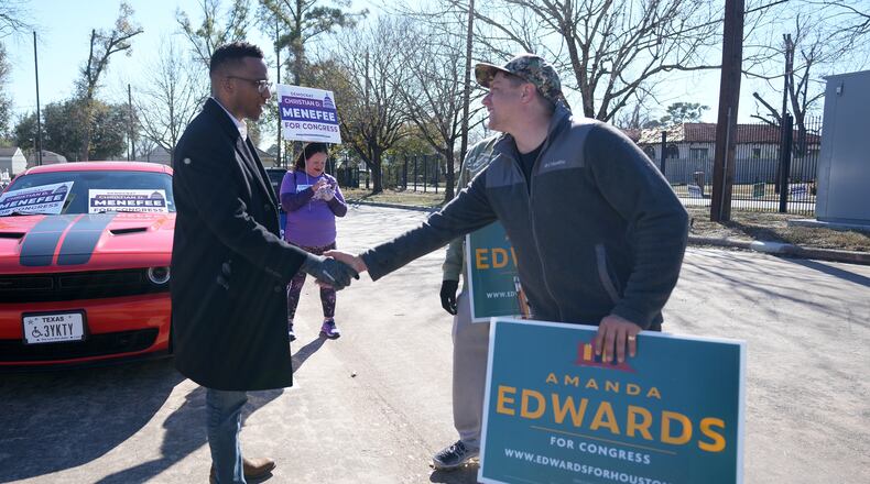 Texas Congressional Candidate Christian D. Menefee shakes hands with Patrick Edge, a poll worker for Amanda Edwards, as he visited a polling location at Acres Homes MultiService Center on Election Day, in Houston, Saturday, Jan. 31, 2026. (AP Photo/ Karen Warren)