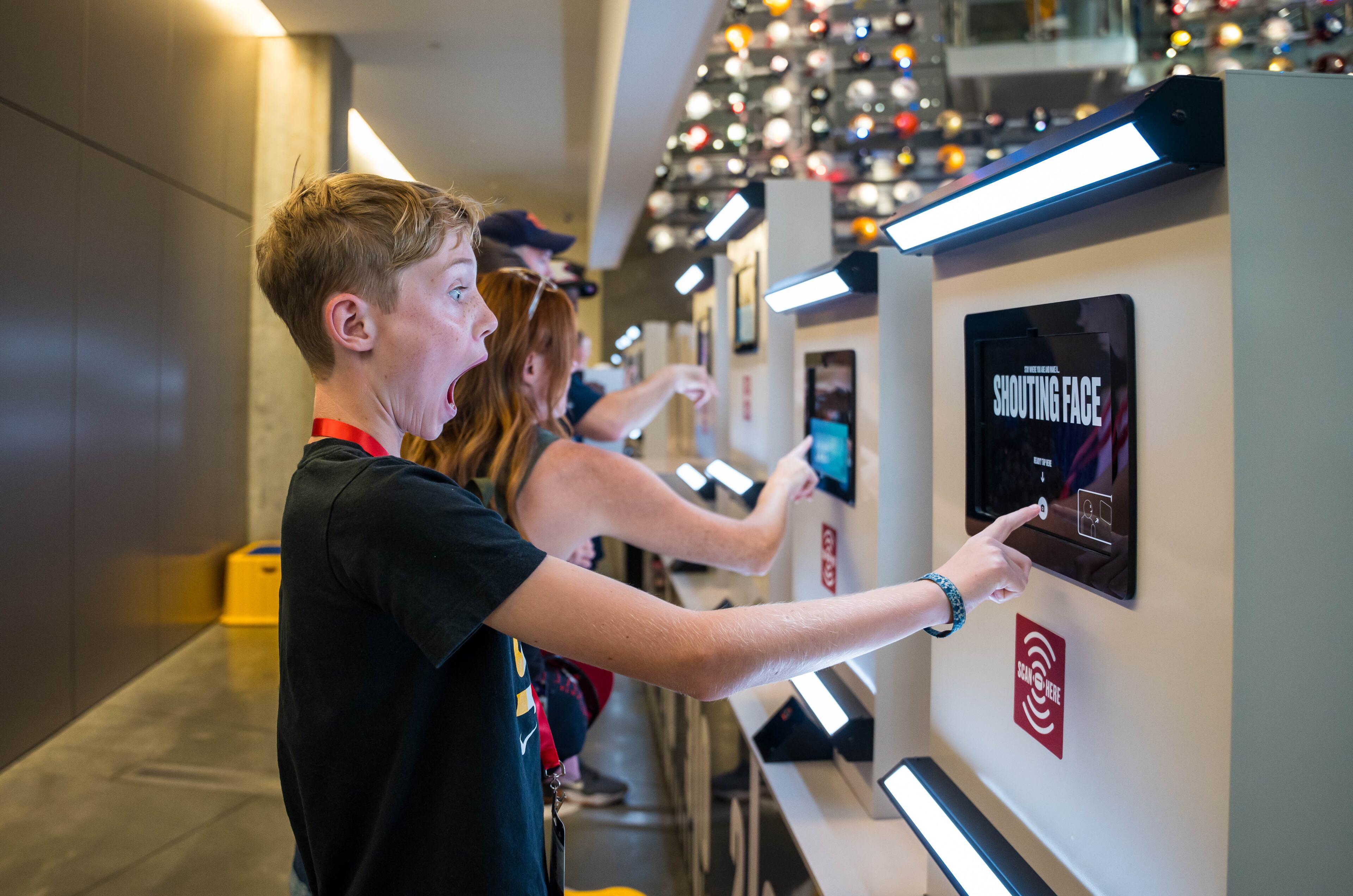 A visitor at the College Football Hall of Fame in Atlanta uses an interactive touch screen display that virtually paints fan faces. (Courtesy of College Football Hall of Fame)