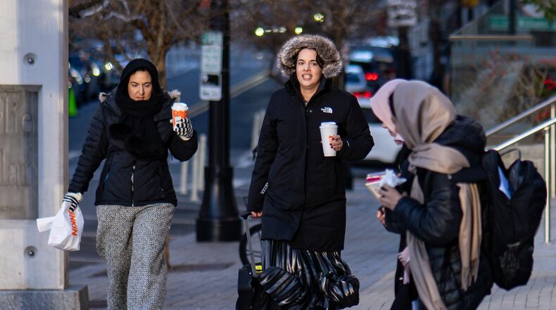 Pedestrians are bundled against freezing temperatures along Forsyth Street in downtown Atlanta, Thursday, Jan. 15, 2026. Metro area temperatures hovered in the 20s and 30s as the sun rose. (Ben Hendren for the AJC)