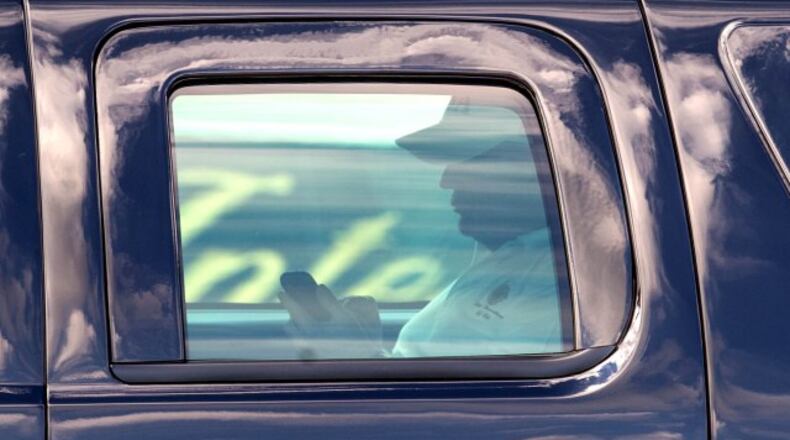 President Donald Trump works his phone after finishing a round of golf at Trump International Golf Club in West Palm Beach, Florida on February 5, 2017. (Allen Eyestone / The Palm Beach Post)