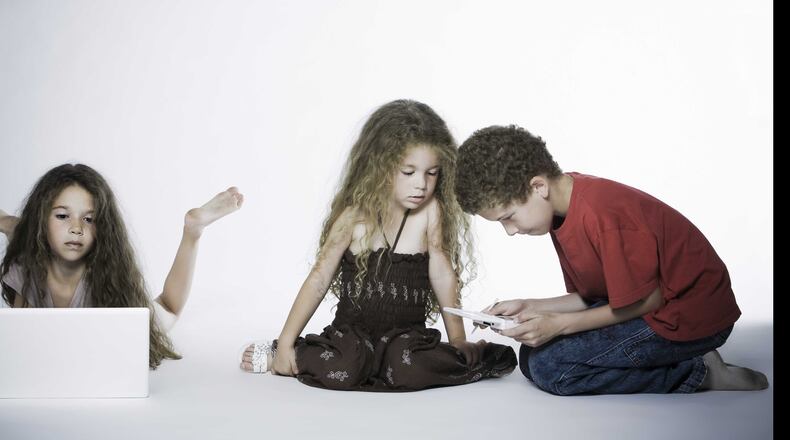 Kids aren’t the only ones fascinated by their technology. Parents are spending large parts of their day on front of screens. (AJC File)