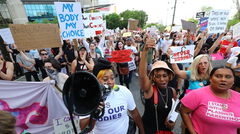 050322 Atlanta: Dozens of protesters march from Centennial Olympic Park to the Georgia Capitol during a rally to defend the right to abortion on Tuesday, May 3, 2022, in Atlanta. “Curtis Compton / Curtis.Compton@ajc.com”