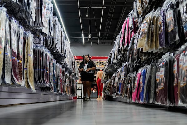 Kinley Sully, a hair stylist who specializes in braids and locs, browses the aisles at Seven Daughters, a beauty supply store in College Park, Ga., Tuesday, May 6, 2025. (AP Photo/Stephanie Scarbrough)