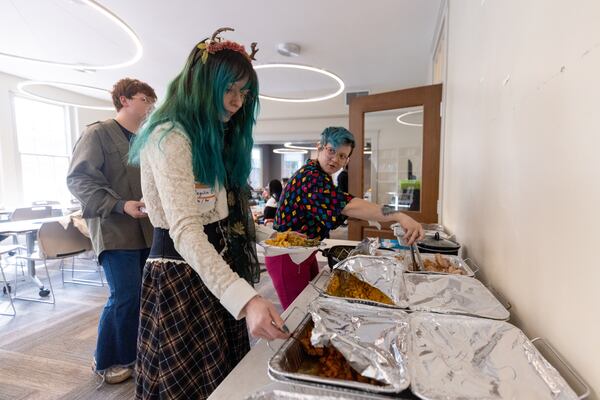 Angelica and Snowflake get food at a Friendsgiving Potluck hosted by Southern Fried Queer Pride at Neighborhood Church in Atlanta, GA, on Sunday, November 20, 2022.(Photo/Jenn Finch)