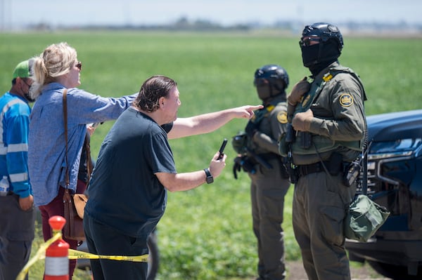 People shout at federal immigration agents during a raid in the agriculture area of Camarillo, Calif., July 10, 2025. (AP Photo/Michael Owen Baker)