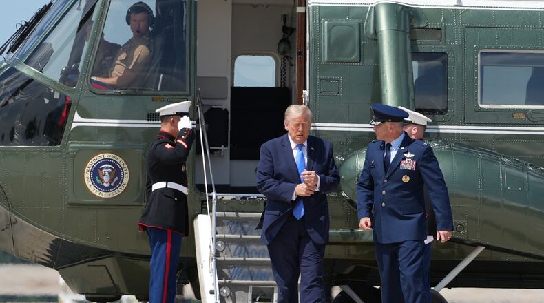 President Donald Trump walks from Marine One with Air Force Col. Christopher M. Robinson, commander of the 89th Airlift Wing, to board Air Force One, Tuesday, Aug. 4, 2026, at Joint Base Andrews, Md. (AP Photo/Mark Schiefelbein)