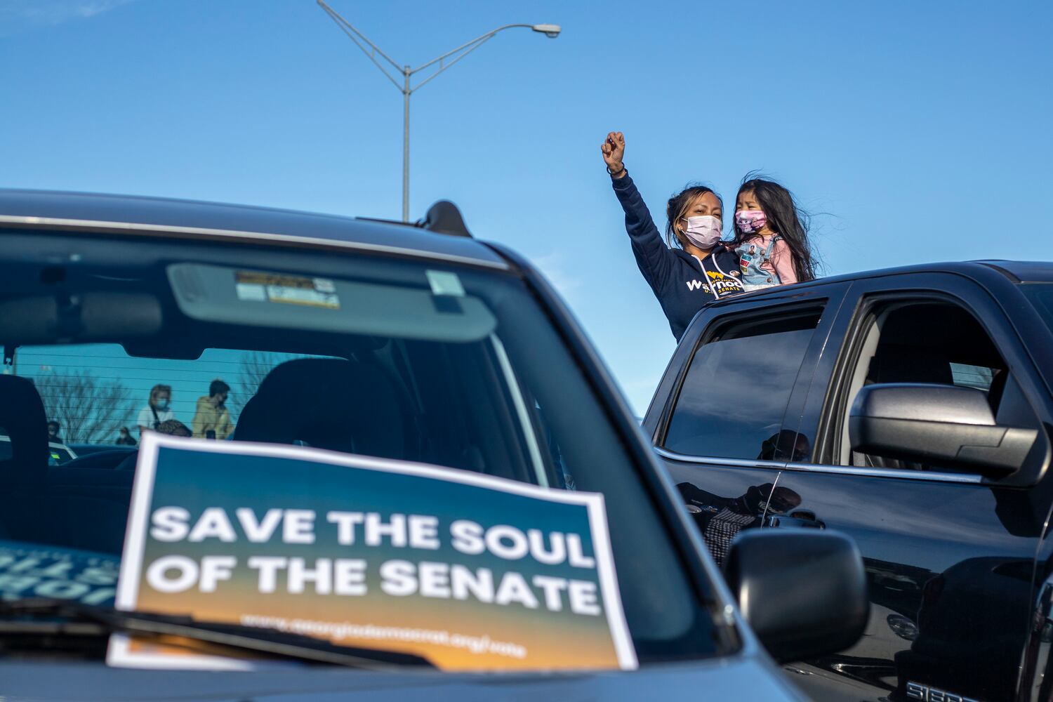 01/04/2021 — Atlanta, Georgia — A woman celebrates from her truck during a Georgia Democrat U.S. Senate campaign rally in Atlanta’s Peoplestown neighborhood, Monday, January 4, 2021. (Alyssa Pointer / Alyssa.Pointer@ajc.com)