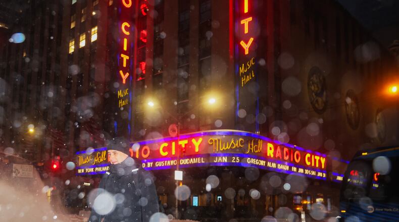 A pedestrian crosses the street near Radio City Music Hall during a winter storm, Sunday, Jan. 25, 2026, in New York. (AP Photo/Heather Khalifa)